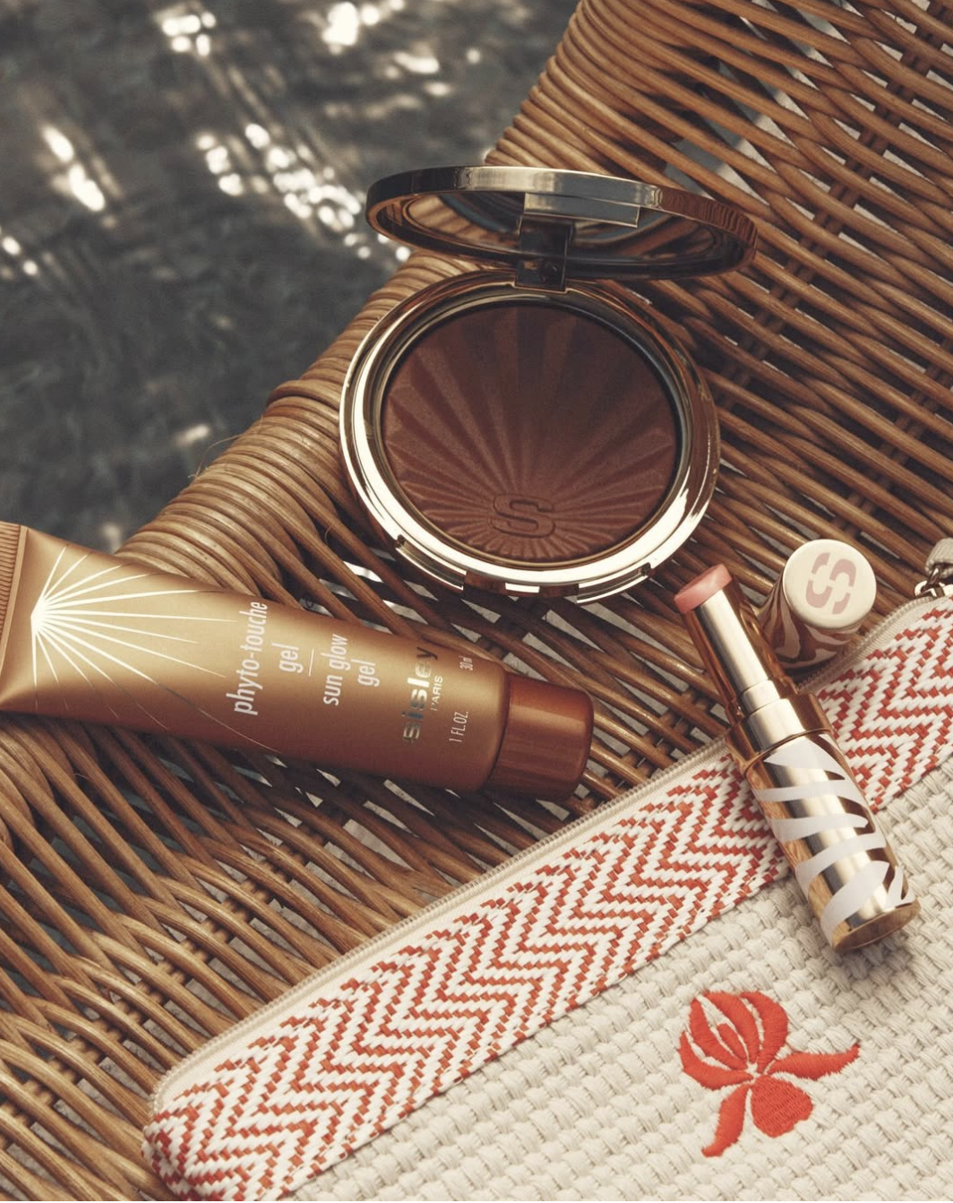 Sisley Paris bronzer, lipstick and beach pouch styled poolside